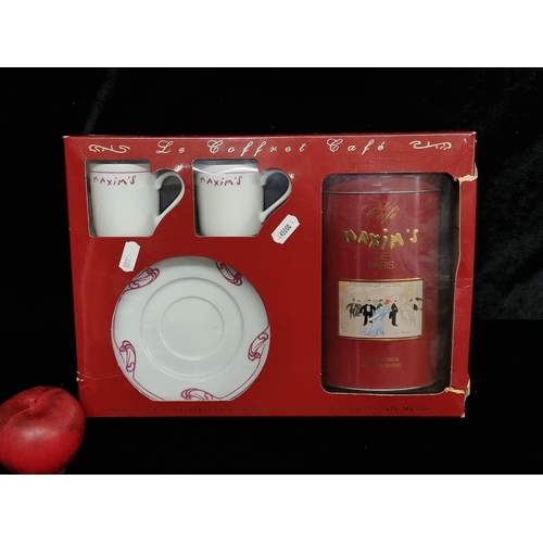 238 - A boxed coffee set from Maxims De Paris including two coffee cups and saucers and a Arabic blend.