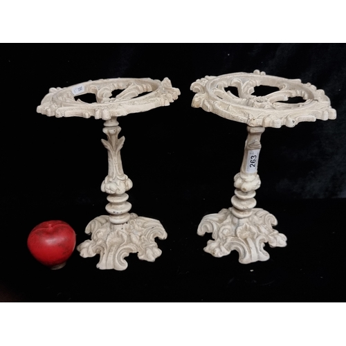 263 - A pair of heavy cast metal plant stands with ornate foliate designs. H27cm