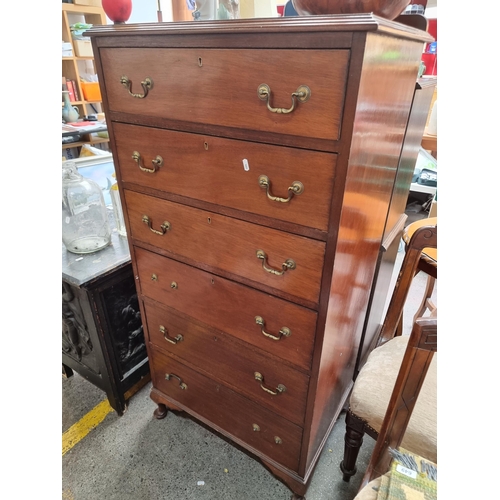 A handsome vintage tall boy chest of drawers with six pull out drawers and brass drop handles (Missing two). H142cm x W71cm x D51cm we should have handles, kids stickers on one side.