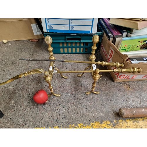 865 - An attractive vintage brass fireside tool set comprising of firedogs, a shovel and a poker.