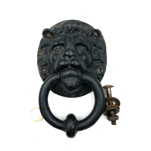 903 - An antique Irish cast iron door knocker with a lion mask. Accompanied by fittings for mounting.