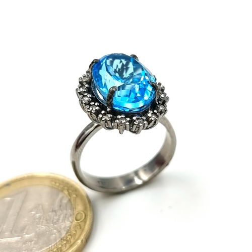 915 - A show stopping vivid Blue Topaz stone ring, set with a huge central stone and a sparkling Diamond s... 