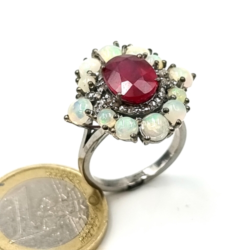 917 - Star Lot : A mesmerising Ruby and Fire Opal ring, set with a shimmering Opal floral flat point halo ... 