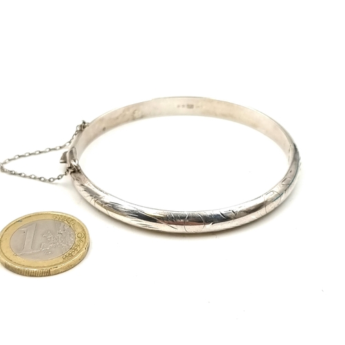 929 - A very attractive sterling silver bangle bracelet with etched detail. Fitted with a safety chain. 
W... 