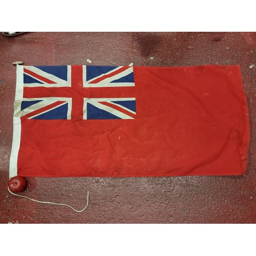 251 - A vintage United Kingdom Red ships Ensign flag. H55cm x W112cm