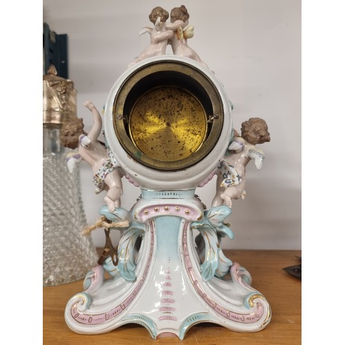 159 - Star Lot : A fabulous Antique porcelain French mantle clock with an ornate case featuring cherubs an... 