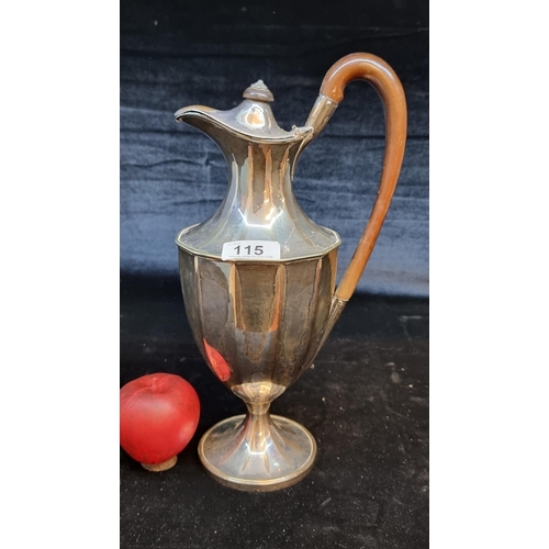 115 - A large antique silver plated jug featuring a wooden handle and finial.