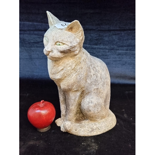 123 - A very heavy reconstituted stone garden figure of a seated cat. H30cm.