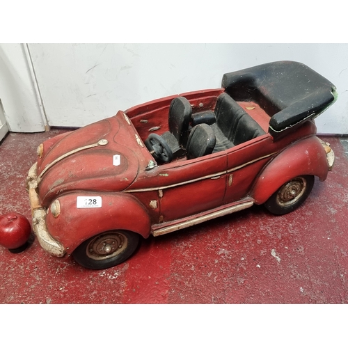 128 - A large model convertible car with rotating wheels. Slight Damage to back. L66cm x H28cm