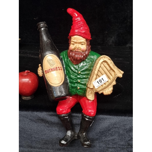 191 - A characterful Guinness advertising figure leprechaun holding a bottle and a harp. In seated positio... 