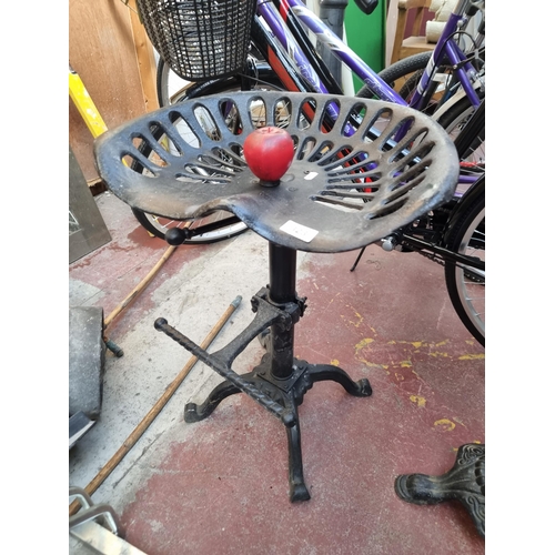 323 - A wonderful cast metal tractor seat stool in a matte black finish.