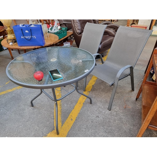 326 - A lovely glass top garden patio table along with two chairs.