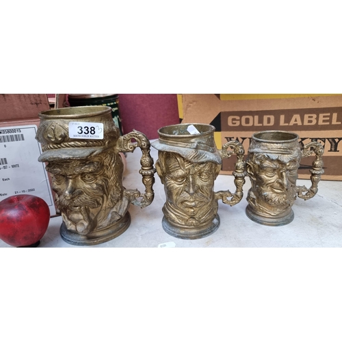 338 - A trio of heavy solid brass graduated Toby jugs.