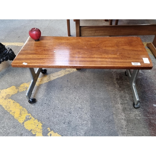 347 - A wonderful 1970's mid century coffee table with metal frame and set on castor wheels.