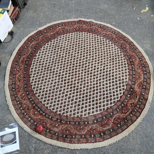 352 - A beautiful circular hand knotted Sarouk Mir wool and cotton Persian rug made in India in a red, nav... 