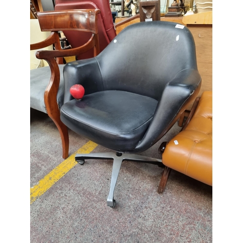 402 - Star Lot: A designer Mid-Century Tan-Sad swivel chair featuring leather upholstery, curved back and ... 