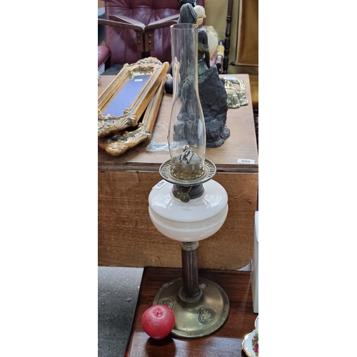 482 - A beautiful early 20th century oil lamp with a blush rose toned font held on a fluted brass stem wit... 