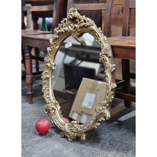 735 - A very elegant oval wall mirror housed in a gilded floral frame. H63cm x W47cm