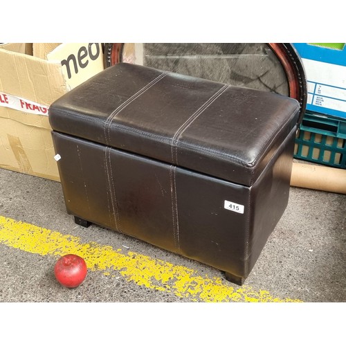 415 - A smart ottoman footstool with hinged lid revealing storage space inside. Upholstered in a brown lea... 