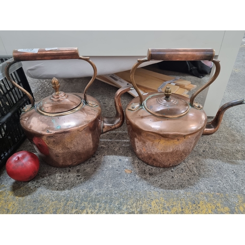 859 - Two large antique stovetop copper kettles with lovely curvilinear handles and spouts.