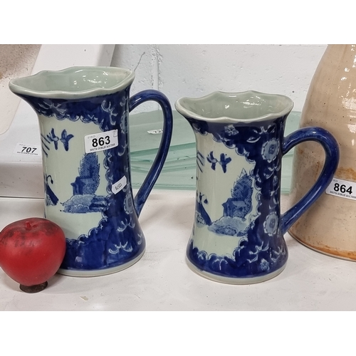 863 - A beautiful pair of vintage hand painted Japanese graduated pitchers. Maker's stamp to base. In very... 