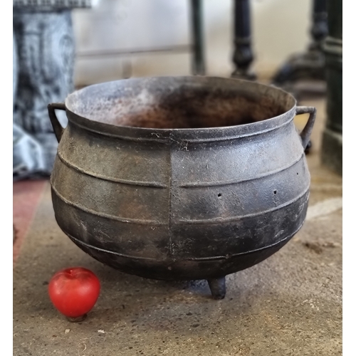 928 - A cast iron cauldron with handles and three feet. H30cm x D40cm 57 days until Halloween.