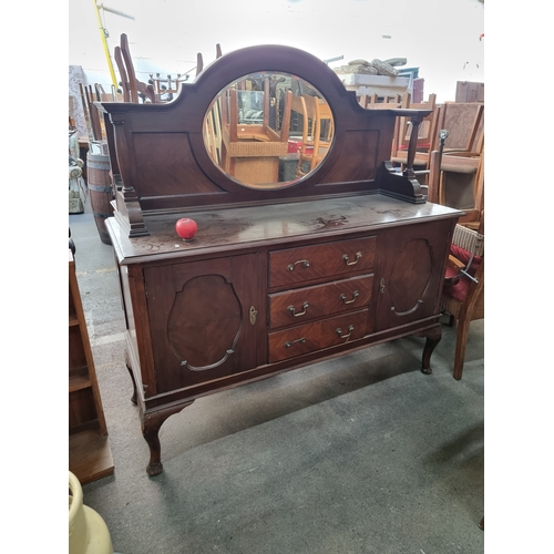 952 - A handsome early 20th century credenza with a bevelled oval mirror to top, pillar supports, three dr... 