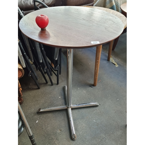 958 - A bar table with a round wooden top held on a chrome base. H100cm x D67cm No reserve €1 start.