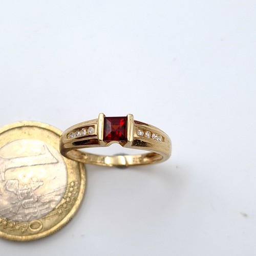 28 - A very attractive 9 carat gold stamped 375 Garnet and Diamond stone ring, featuring a channel cut Di... 