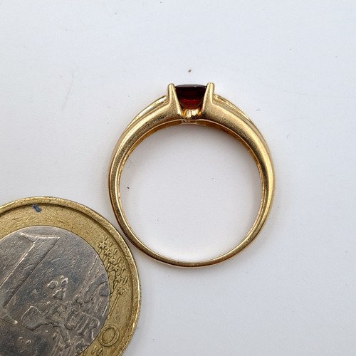 28 - A very attractive 9 carat gold stamped 375 Garnet and Diamond stone ring, featuring a channel cut Di... 