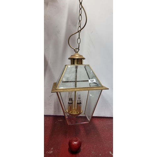 127 - An elegant  large pendant hall lantern with beveled glass panels with a brass frame and fittings for... 