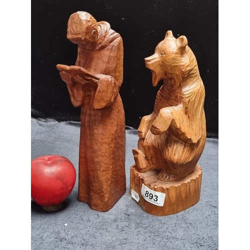 893 - Two hand carved wooden figures of a surprised bear and a monk reading scripture.