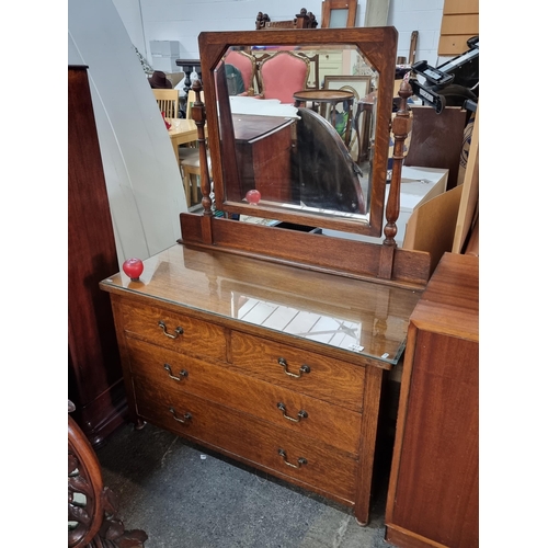 917 - Star Lot : An elegant early 20th century tiger oak dresser with articulated bevelled mirror featurin... 