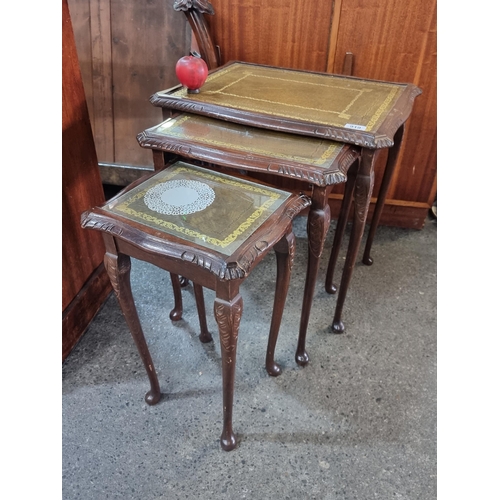 919 - A handsome vintage three part nesting table with tooled leather gilded tops, carved edges and cabrio... 