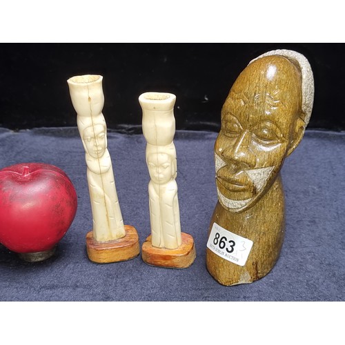 An interesting selection of three items, including a pair of hand-carved bone candlesticks and a heavy marble African tribal bust.