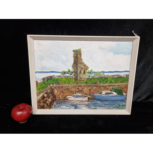 79 - An original acrylic on board painting featuring boats moored at the shore with a ruinous tower to th... 