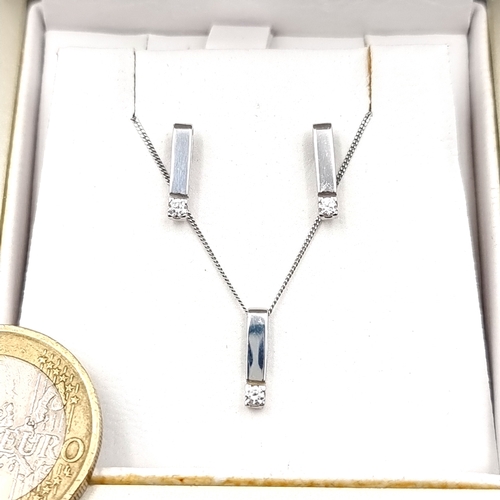 21 - Star Lot : A jewellery suite comprising of a 9 carat white gold gem set pendant with matching stud e... 