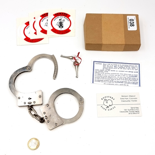 38 - A pair of Harley Davidson branded hand cuffs together with two keys.. Comes with instructions. Total... 