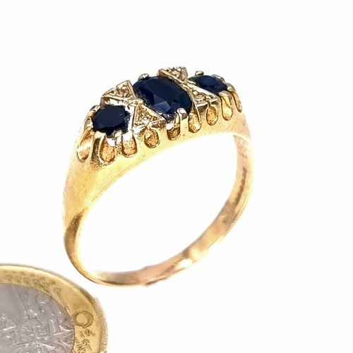 43 - Star Lot : A nice example of a three stone sapphire ring set in 9 carat gold with gem set spacers. S... 