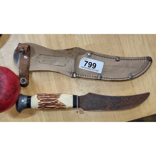 799 - A vintage haunting knife with belt sheath intact.