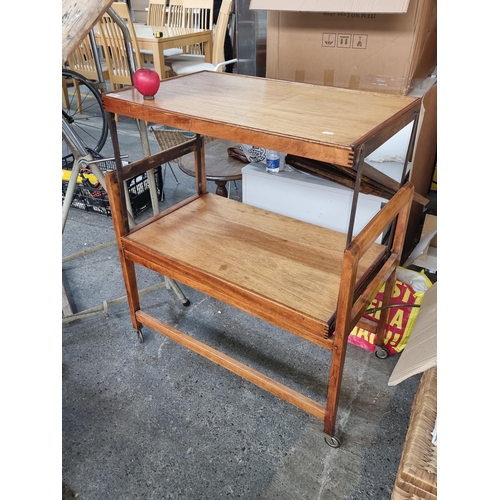 820 - Star Lot : A Mid Century dual purpose shelving unit which folds to form a table. Set on original cas... 