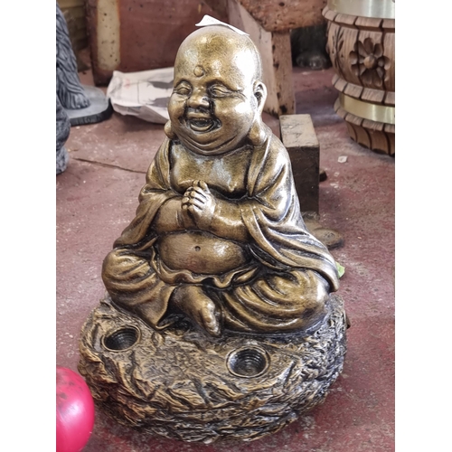 829 - A large reconstituted stone garden figure of Buddha in a gilded finish.