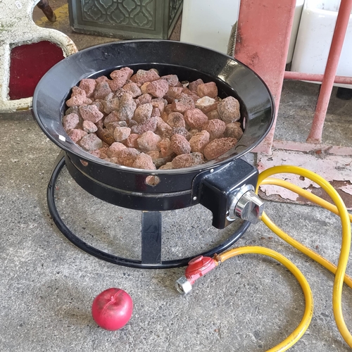 837 - An outdoor gas portable fire place with a metal basin, coals and a hose with a propane fitting.