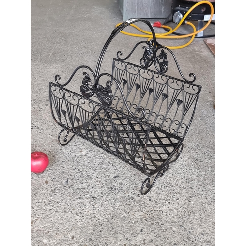 840 - An elegant metal firewood basket with curvilinear detailing.