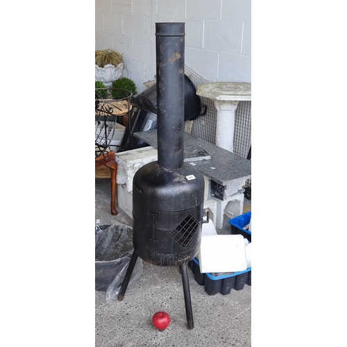 841 - An outdoor chimenea with crated openings and three legs. Door non functional. H120cm