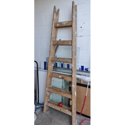 844 - A vintage wooden A-line ladder with twelve steps total and a connecting rope. H184cm