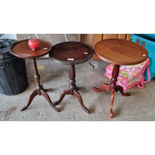 852 - Three elegant wine tables featuring turned detail to stems and one with string inlay to top.