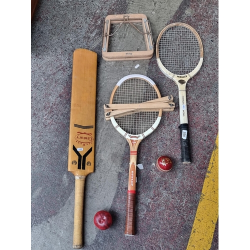 928 - Four vintage sporting items including two tennis rackets, along with a cricket bat and ball.