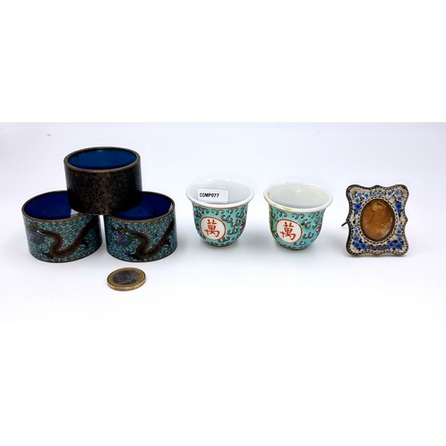 880 - Two vintage Chinese porcelain tea cups along with three enameled napkin rings and a miniature photo ... 