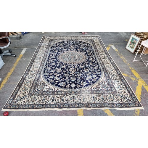 947 - Star Lot: A very large hand knotted wool rug with a highly ornate floral design in shades of cream a... 